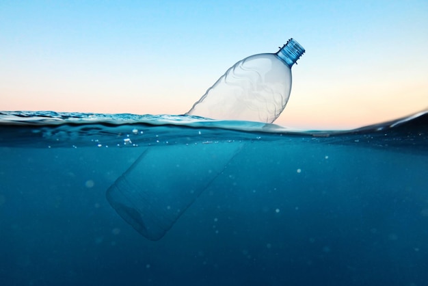 Empty plastic bottle floats in water Ocean pollution concept Global warming View under water