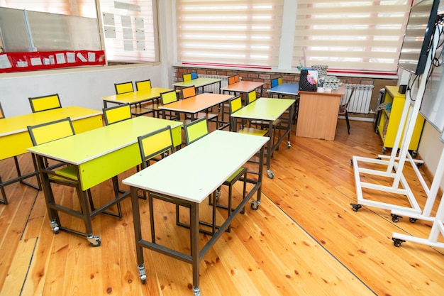 Foto aula scolastica vuota con panche e tavoli