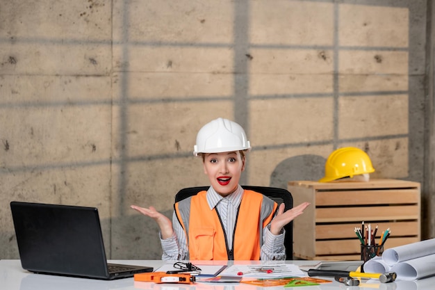 Engineer civil worker in helmet and vest smart young cute blonde girl waving hands