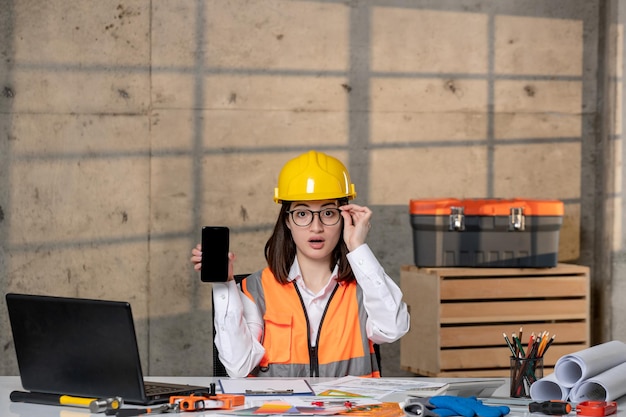 Engineer cute young smart brunette girl civil worker in helmet and vest excited