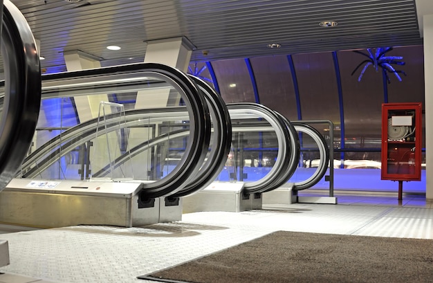 A escalator with a blue light on the ceiling