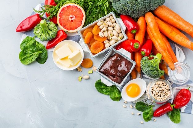 Foto evenwichtige voeding, gezond schoon eten concept. assortiment van voedselbronnen rijk aan vitamine a op een keukentafel. ruimte achtergrond kopiëren