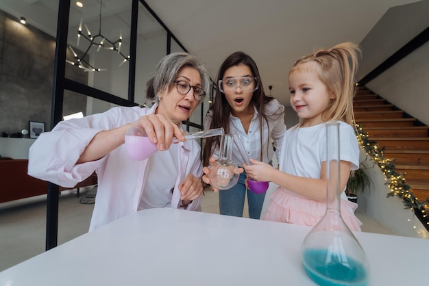 Family doing chemical experiment mixing flasks indoors close view