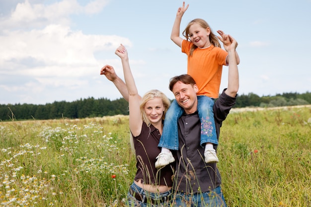 family posing in a grass field