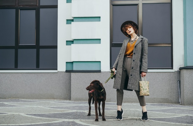 Fashionable photo of a woman with a dog on the street