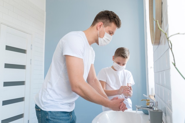 Father and son washing their hands in the sink