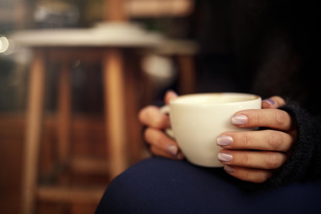 Female hand hold hot coffee cup