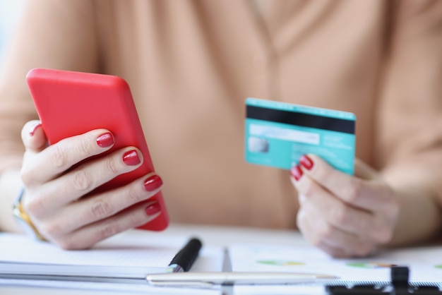 In female hands plastic credit card and smartphone