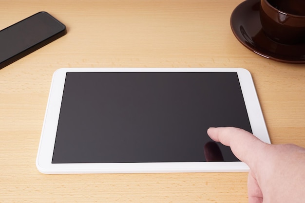 Photo finger touching blank touchscreen on tablet computer