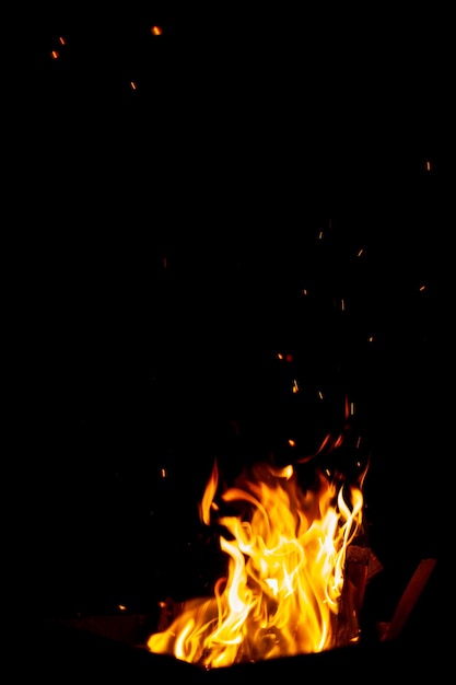 The fire burns at night Fire and sparks on a black background