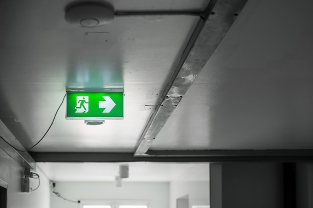 Photo fire emergency exit sign on the wall background inside building. safety concept