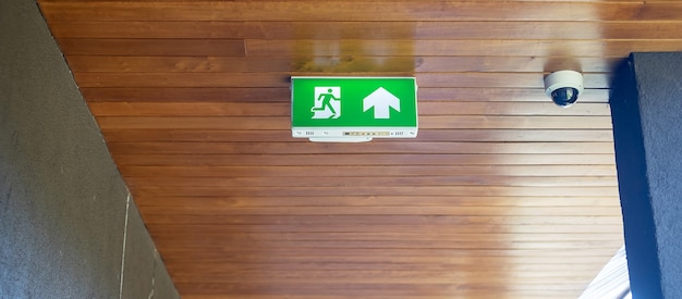 Photo fire emergency exit sign on the wall background inside building. safety concept