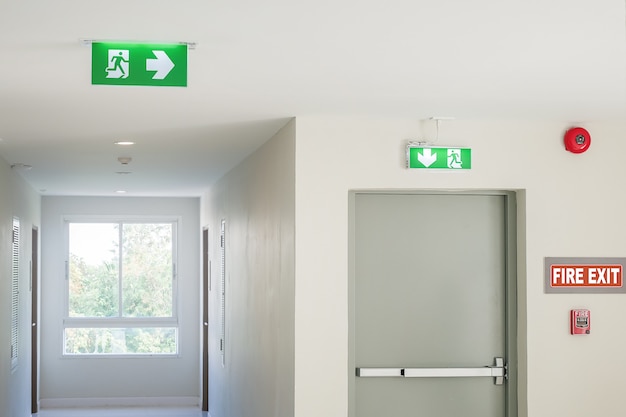 Photo fire exit sign with light on the path way in the hotel or office