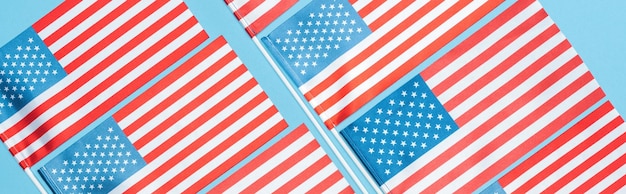 Photo flat lay with american flags on sticks on blue background panoramic shot