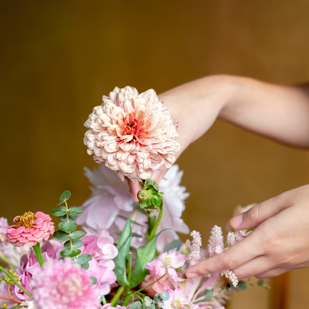 Florist arranging bouquet with pip salmon