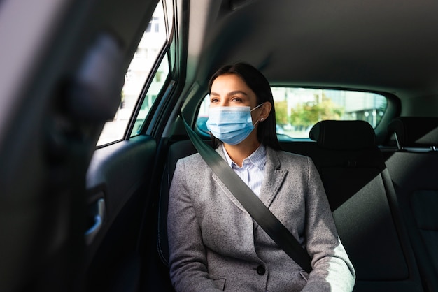 Front view of businesswoman with medical mask in the car