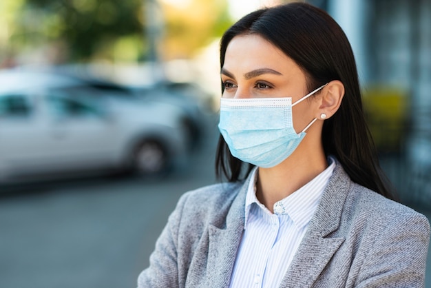 Front view of businesswoman with medical mask and copy space