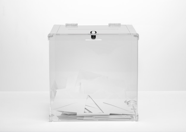 Front view transparent ballot box filled with vote bulletins