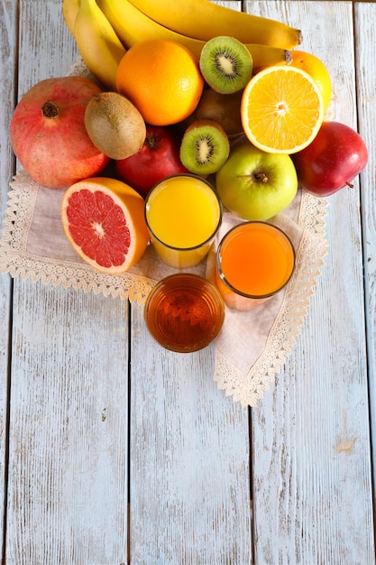 Foto succo di frutta e verdura e frutta fresca su tovagliolo su fondo di legno