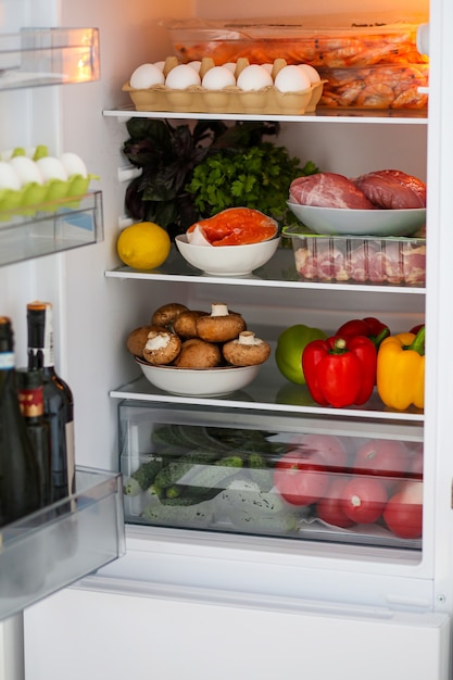 Full fridge of healthy food proper nutrition the keto diet refrigerator with healthy food products in the refrigerator meat with vegetables the concept of proper nutrition red fish