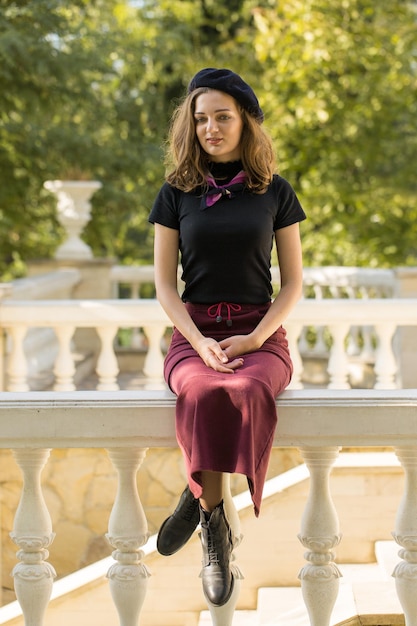 The girl in beret and skirt in the park Cute girl portrait in french style