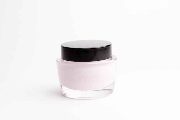 Glass jar with face cream on a white background