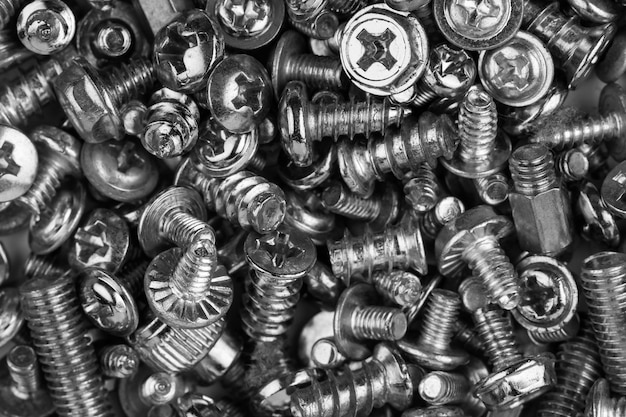 Gray texture background of many randomly scattered computer screws