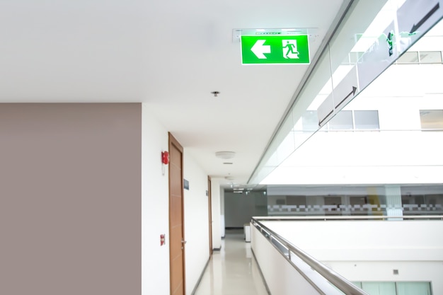 Photo the green emergency fire escape sign on the ceiling