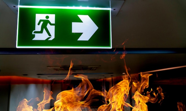 Photo green fire escape sign hang on the ceiling in the office