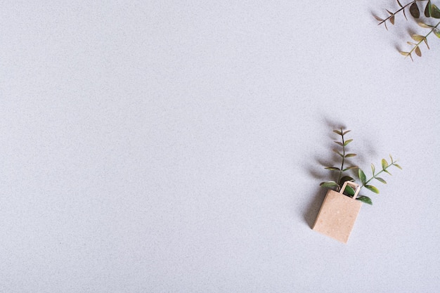 Photo green friday paper craft bag with branches on a green background top view copy space