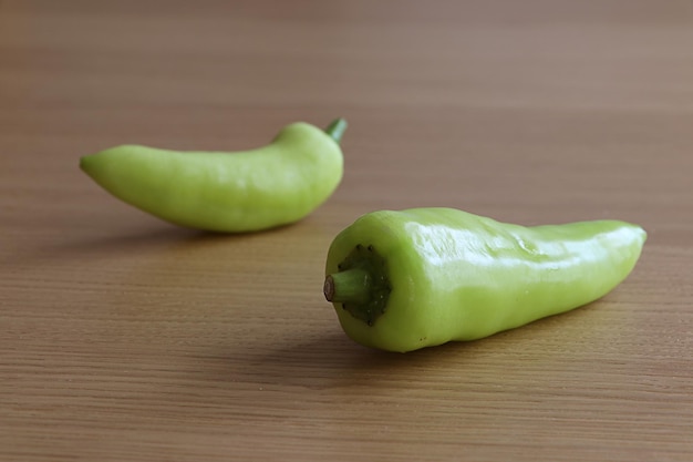 Green pepper on wooden background.