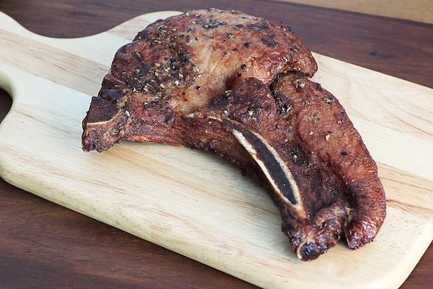 Grilled T-bone steak on cutting board.