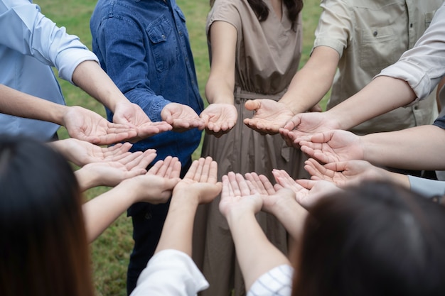 Photo 아시아 사람들의 그룹은 훈련 팀 빌딩에서 함께 좋은 느낌을 얻고 공유하기 위해 오른손을 들고 부드럽게 처리합니다.