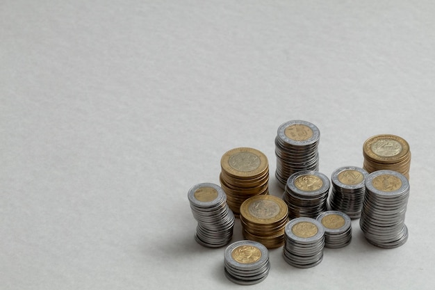 Group of coins stacked on the corner of a table with copy space Mexican pesos