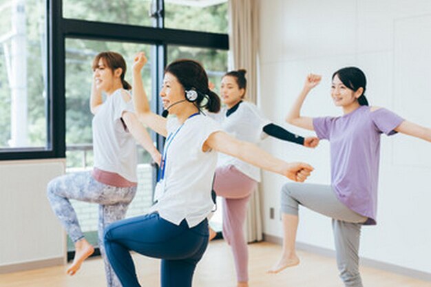 Photo 紫のシャツを着た女性と一緒にヨガをしている女性のグループ