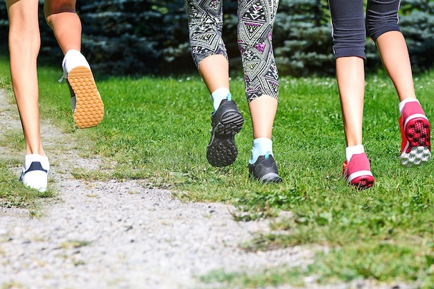 Group of young people running in the park in the sunny day