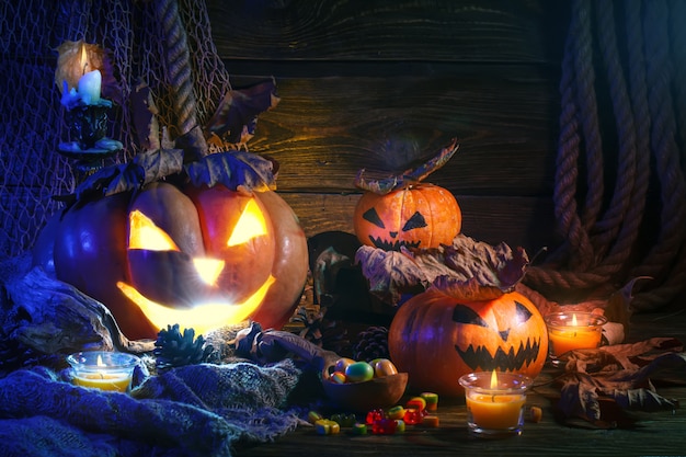 Halloween pumpkins and candy on wooden table.