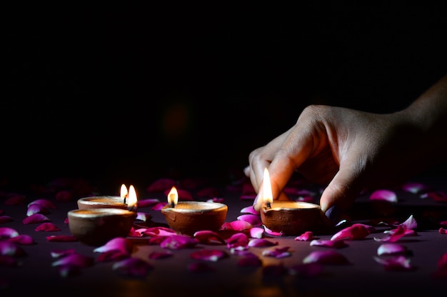 Hand holding and arranging lantern (Diya) during Diwali Festival of Lights