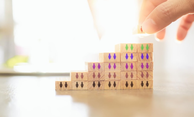 Hand of manager putting wood block on top pyramid Human resource and recruitment business concept