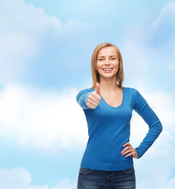 happiness, gesture and people concept - smiling young woman in casual clothes showing thumbs up