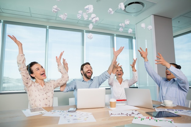 Photo happy business executives throwing crumpled paper in air