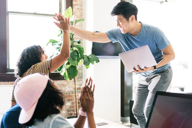 Foto felici e diversi colleghi in una startup che fanno il cinque