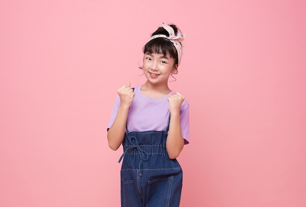 Photo happy lucky glad cheerful asian girl celebrating great success isolated on pink background