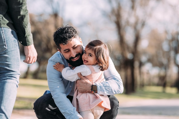 Happy and smiling girl hugging her dad in the park