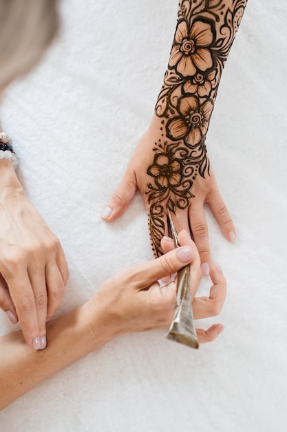 Photo henna tattoo on woman hands artist drawing arabic mehndi