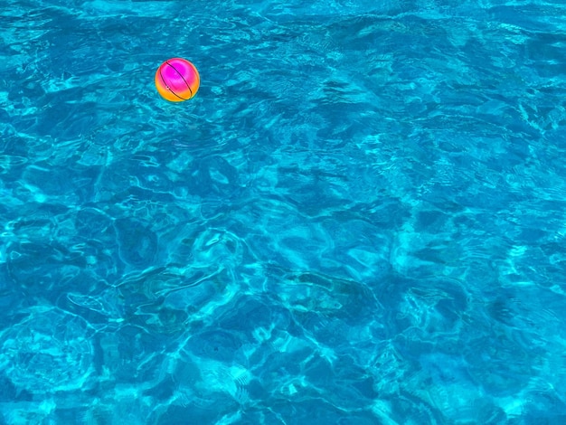 Photo high angle view of a colorful ball floating on water in a swimming pool