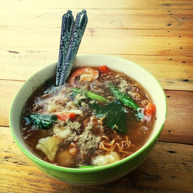 High angle view of noodle soup on wooden table