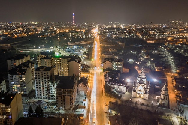 High rise apartment buildings with illuminated windows in city residential area at night.