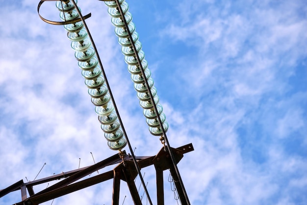 High voltage insulation string on steel pillar with electric power lines for safe delivering of electrical energy through cable wires on long distance