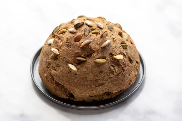 Homemade bread with pumpkin seeds on the board.